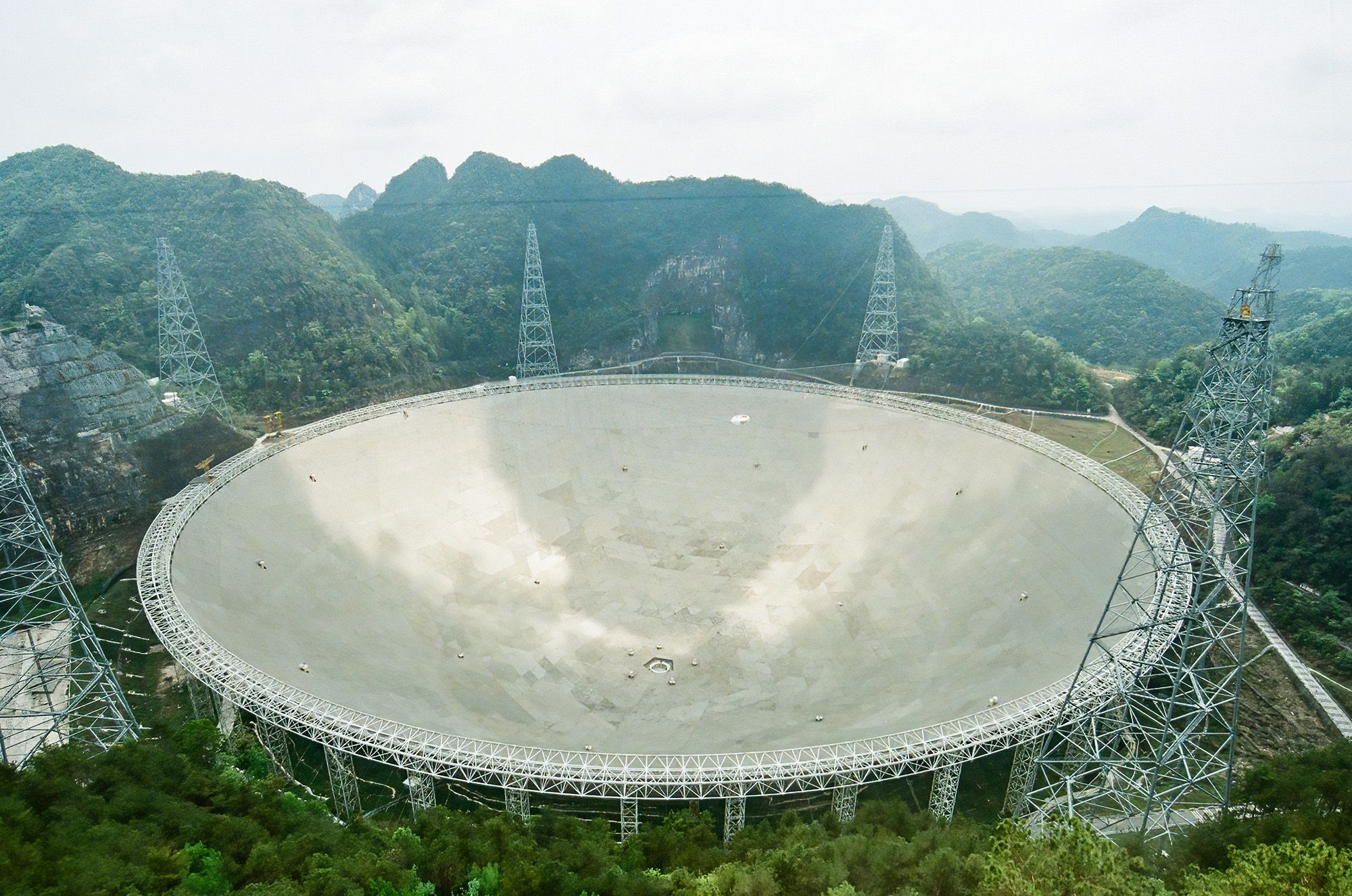 A large circular disk is seen in the middle of a forrested region.