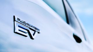 A close-up of the Plug-in Hybrid badge on the Mitsubishi Outlander PHEV