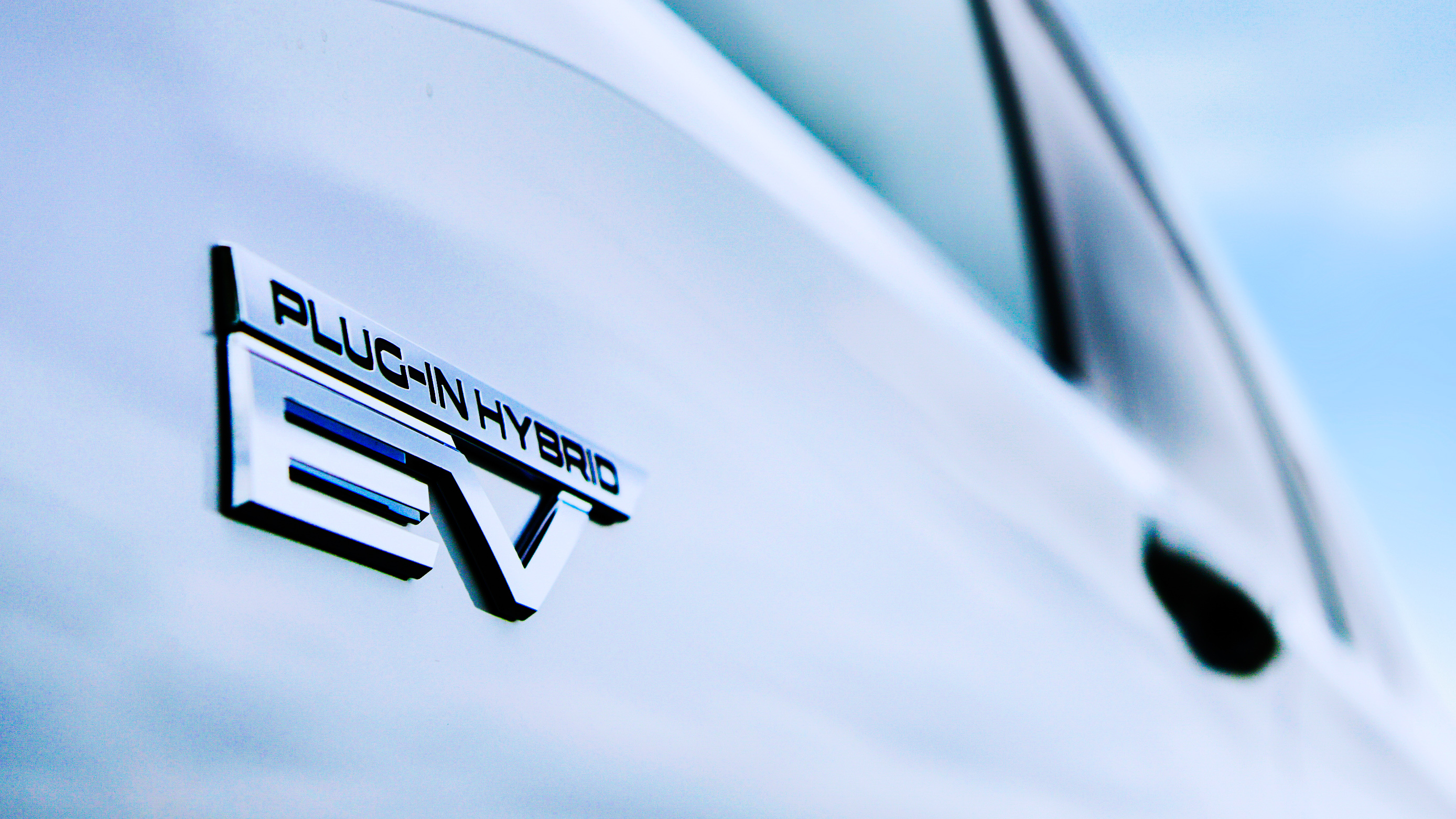 A close-up of the Plug-in Hybrid badge on the Mitsubishi Outlander PHEV