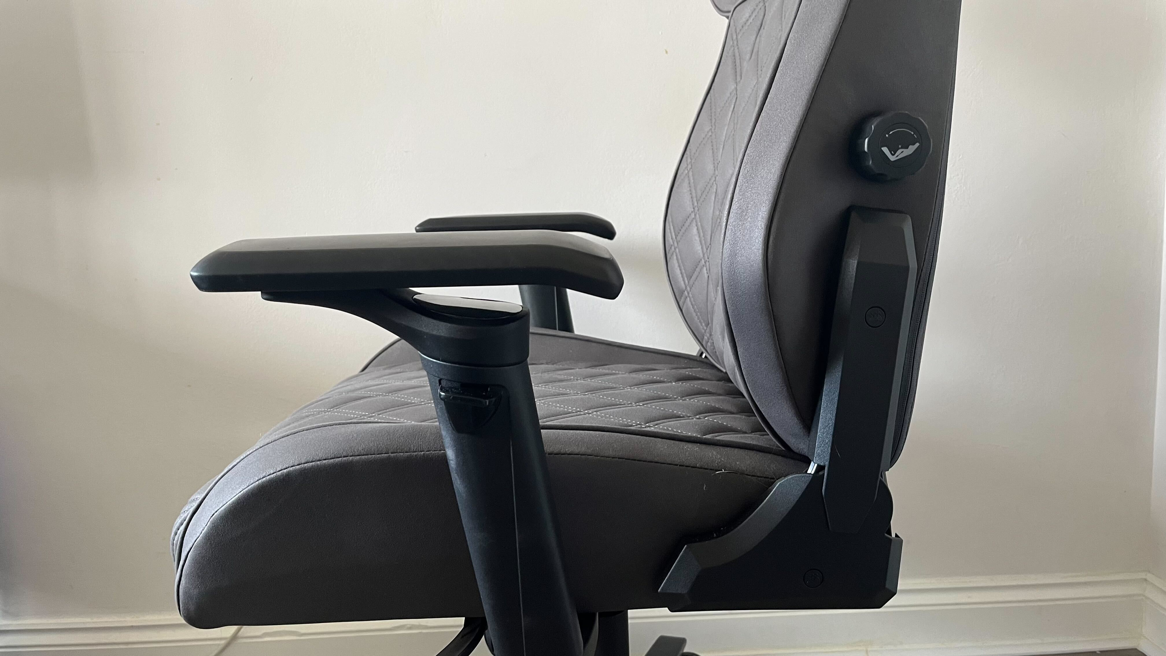 A side on shot of a Corsair Gaming Chair in a plain room.