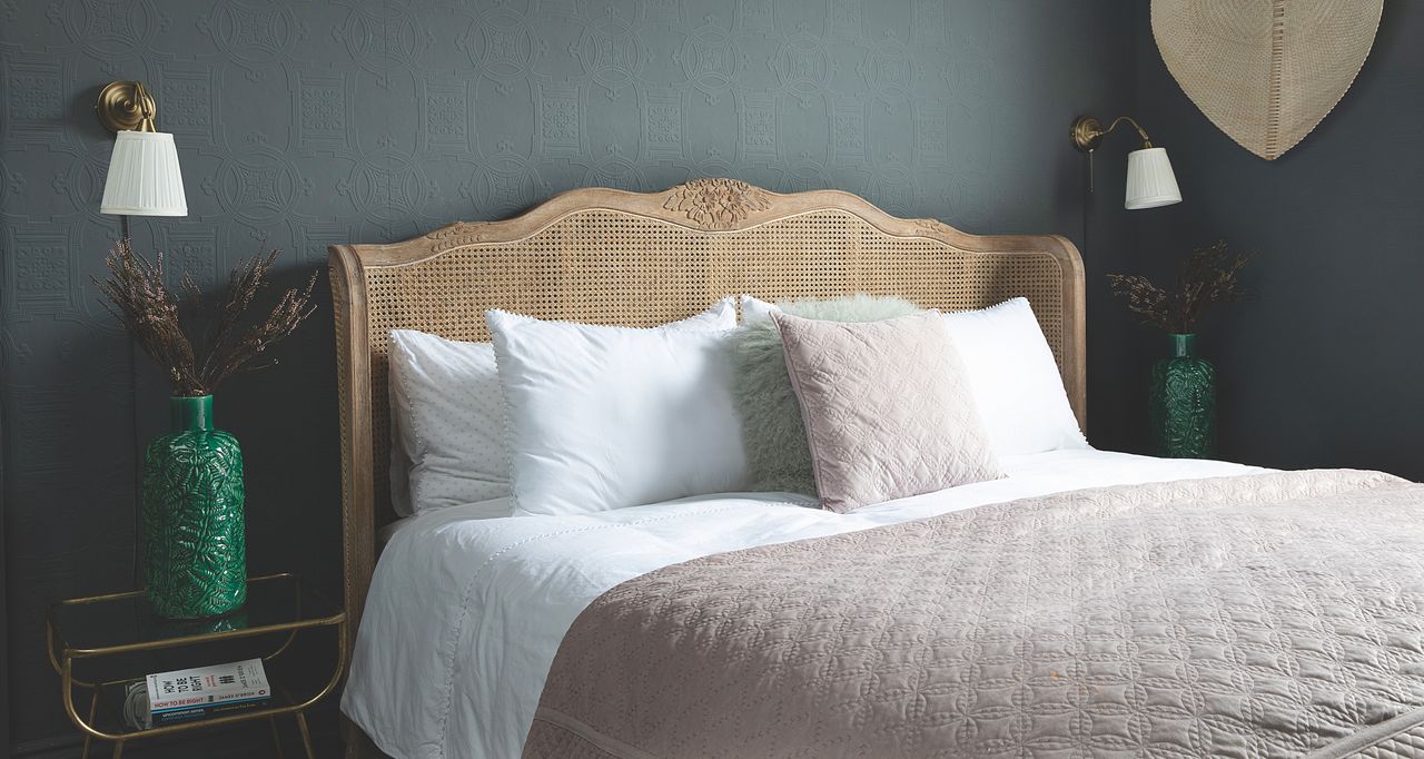 Bedroom with rattan headboard and two white and bronze wall lights