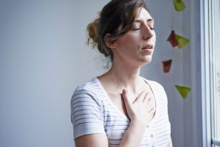Woman with asthma holds her chest