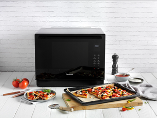 panasonic microwave on kitchen counter with pizza