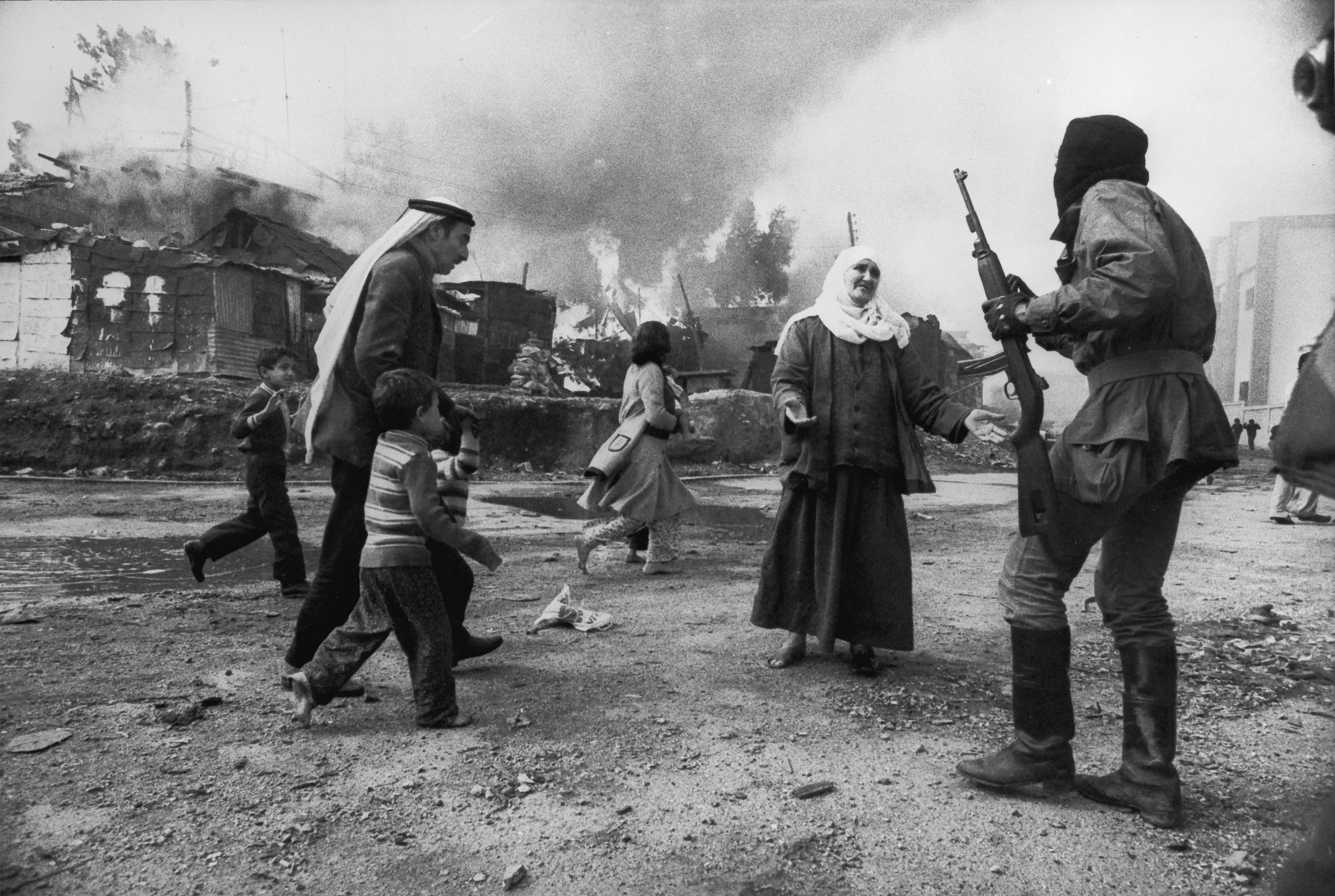 A Palestinain woman pleads with Christian militia in Beirut while a man tries to take children to safety during the Lebanese civil war, 19th January 1976. (Photo by Francoise De Mulder/Roger Viollet via Getty Images)