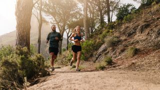 Man and woman running along trail