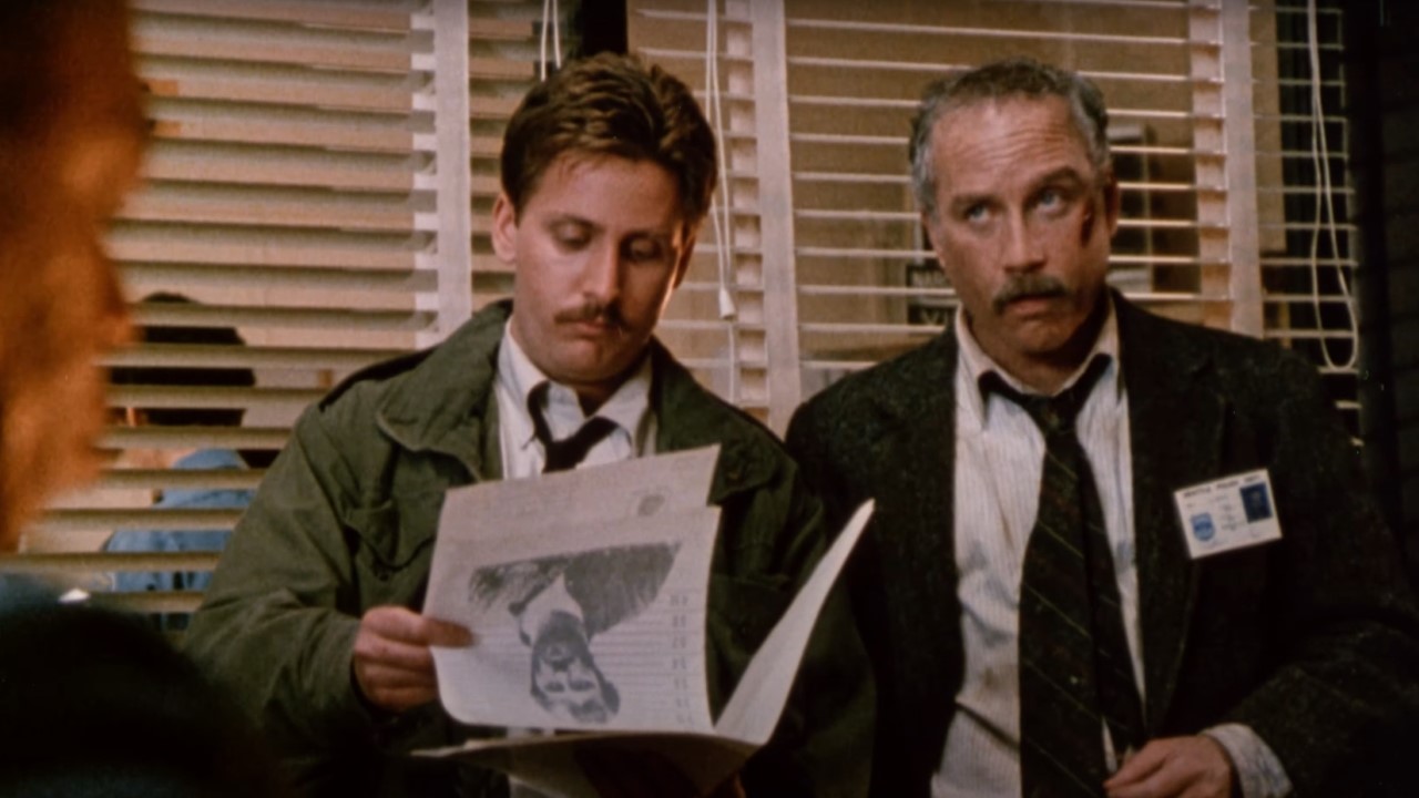 Emilio Estevez and Richard Dreyfuss in police department office looking at files in Stakeout