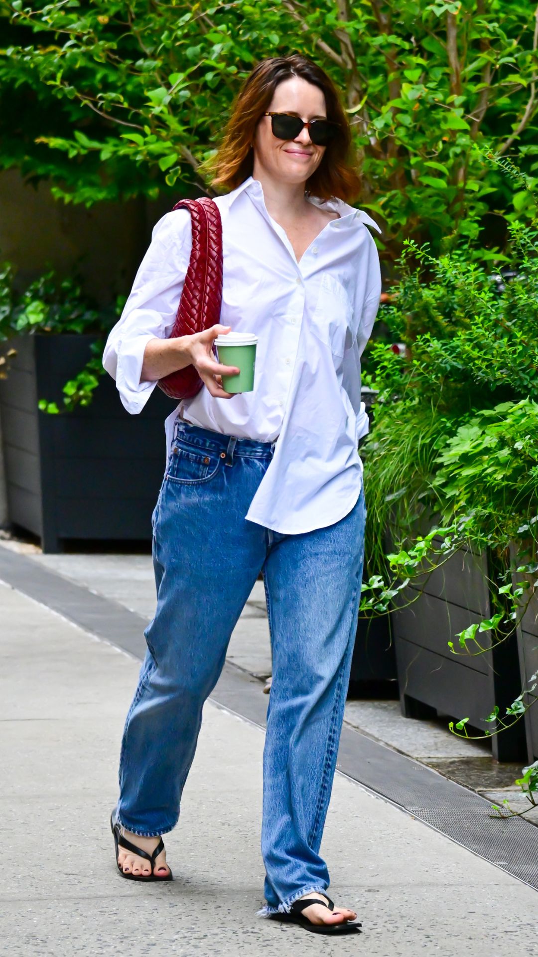CLAIRE FOY WEARING A WHITE SHIRT AND JEANS WITH A BOTTEGA BAG