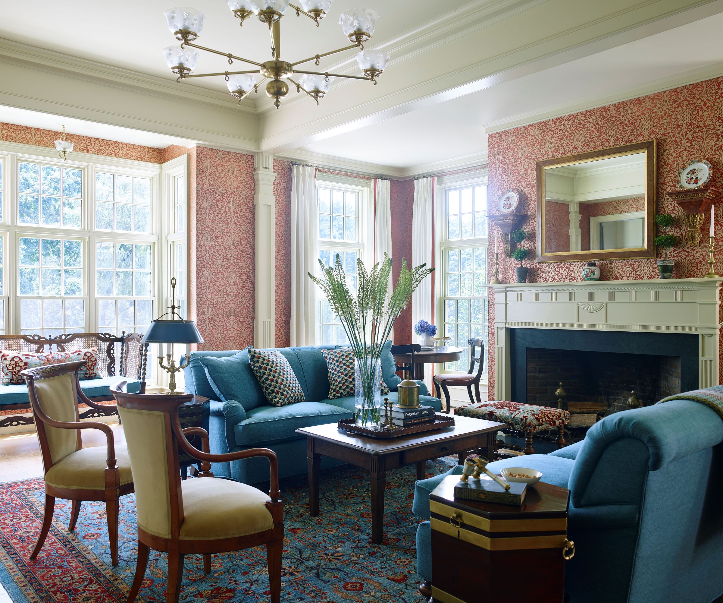 Traditional living room with wallpaper, fireplace, with blue sofa and wood coffee table
