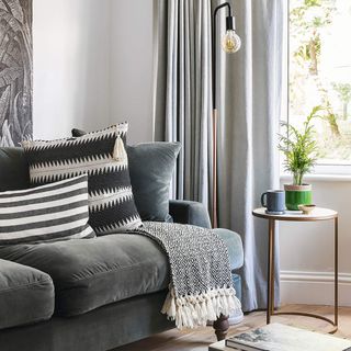 Grey living room with sofa, grey curtains and monochrome cushions.