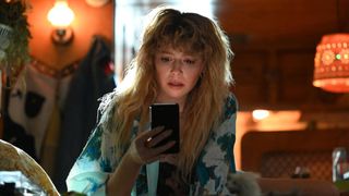 Natasha Lyonne as Charlie Cale looks down at a phone in Poker Face
