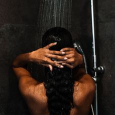 best drugstore shampoo - woman washing her hair in the shower Getty Images 1143520000