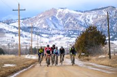 Framed by the Rocky Mountains, the front group of riders endures in windy conditions at 2025 Old Man Winter