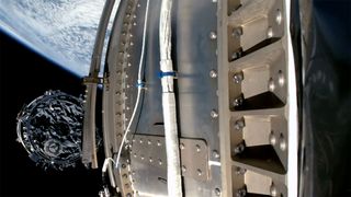 photo of a cylindrical spacecraft deploying from its rocket in orbit, with earth in the background