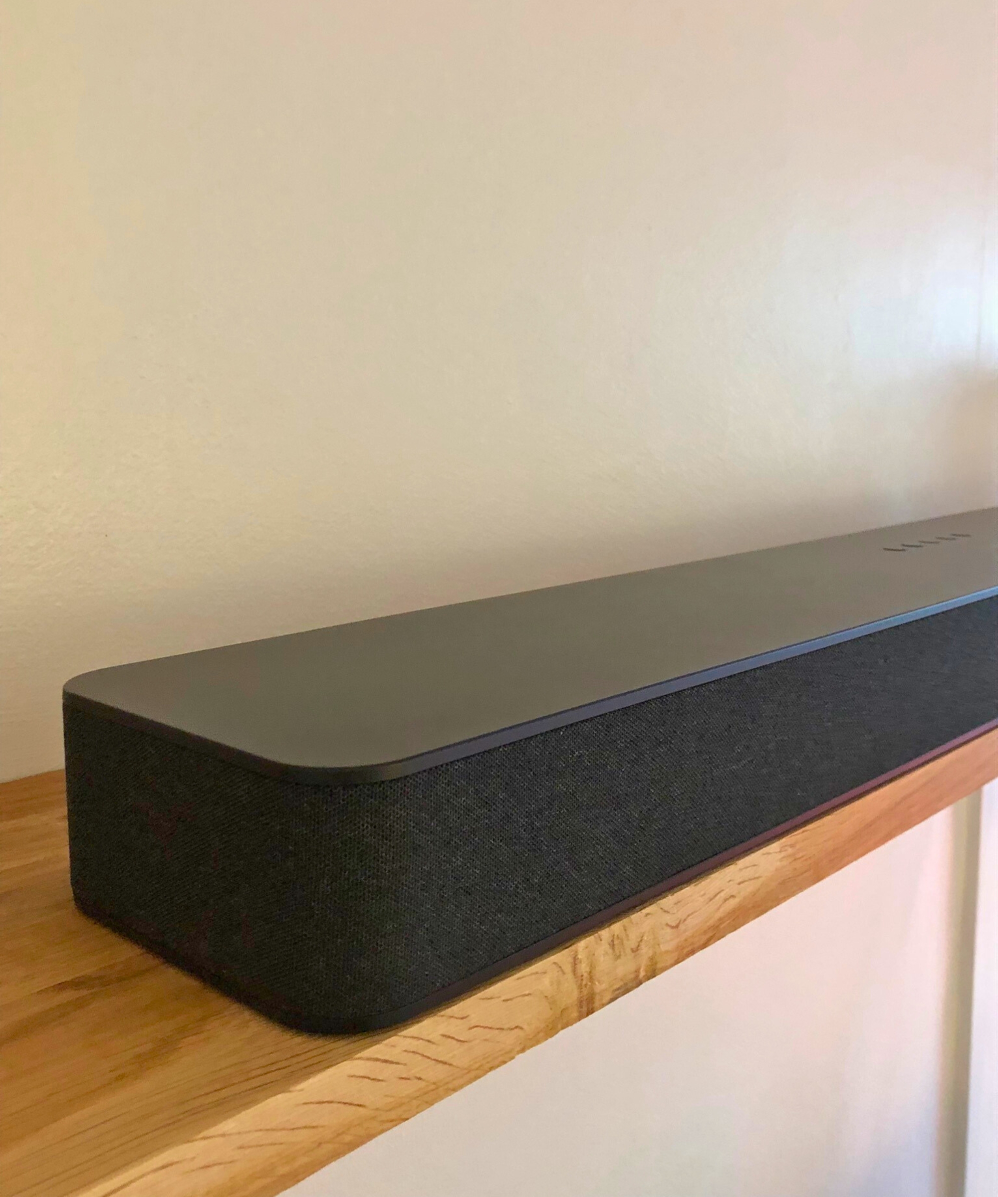 Closeup of the Fire TV Soundbar Plus on wooden shelf in Dan Fauzi's home.