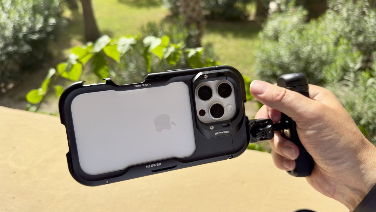 An iPhone in a Neewer cage held in a hand