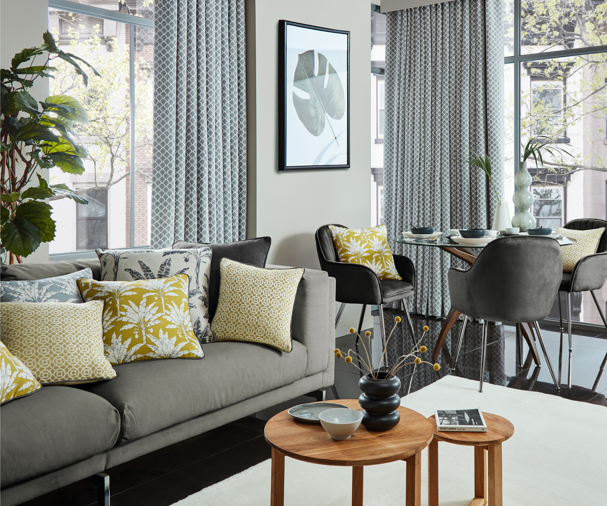 open plan living room with grey sofas, yellow cushions and floor to ceiling curtains