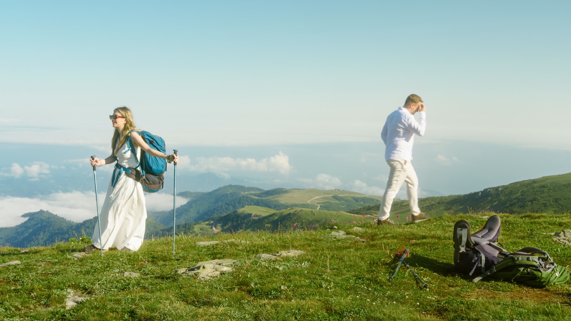Man and woman walking in opposite directions on a scenic mountain top