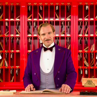 Monsieur Gustave H. (Ralph Fiennes) the legendary concierge at reception in ‘The Grand Budapest Hotel’ (2014) directed by Wes Anderson.