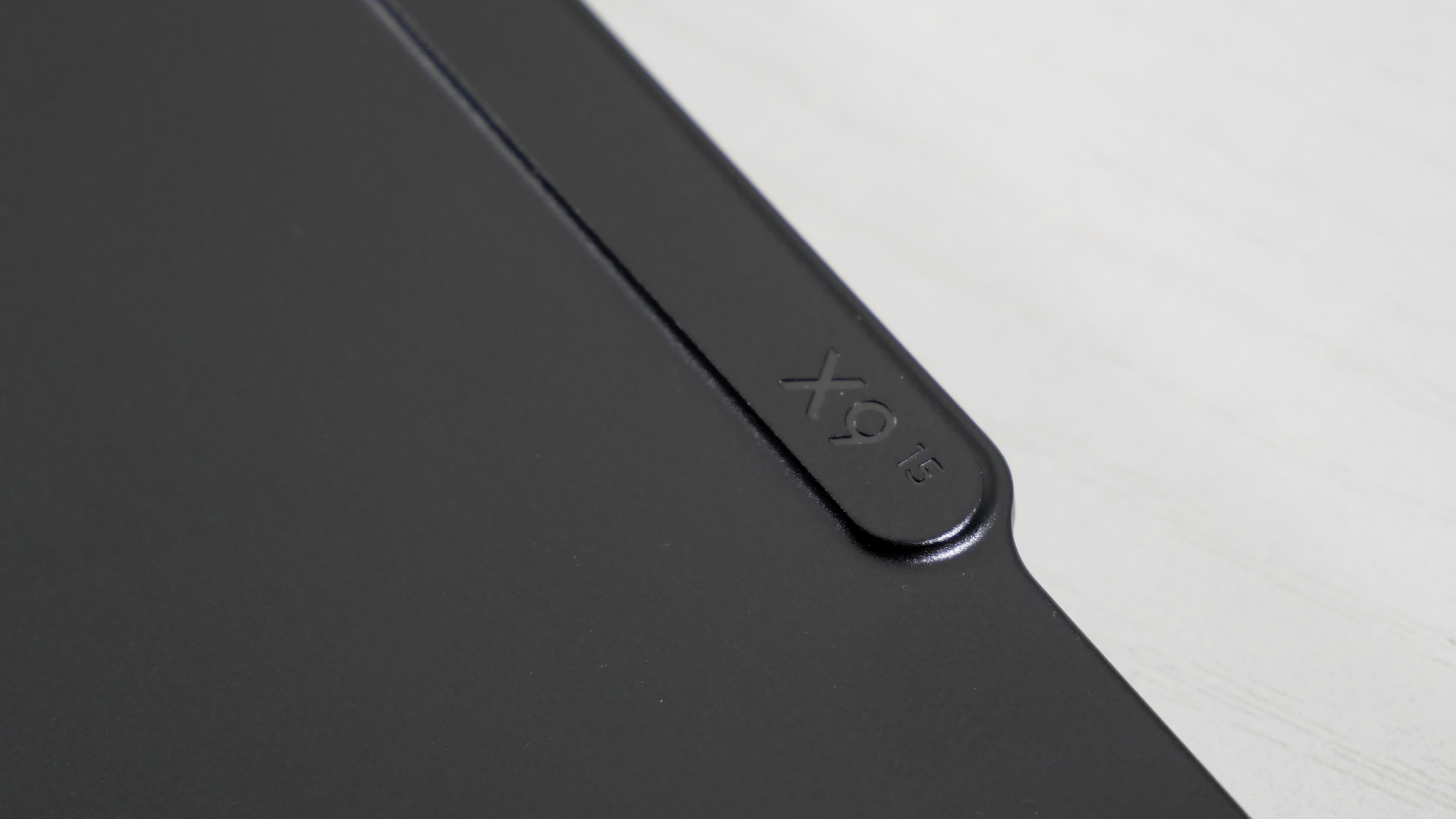 Lenovo ThinkPad X9-15 Gen 1 Aura Edition closed on a white desk, highlighting the X9-15 logo on the back of the webcam.