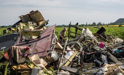 A man picks through the wreckage of Flight 17