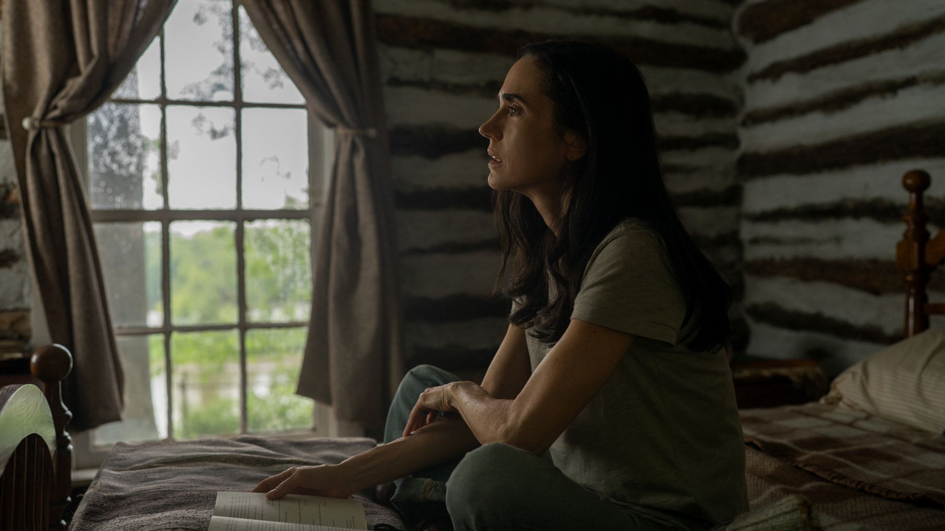 a woman sitting cross-legged in a bedroom
