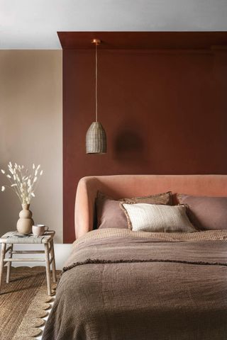 A small bedroom painted in terracotta and cream