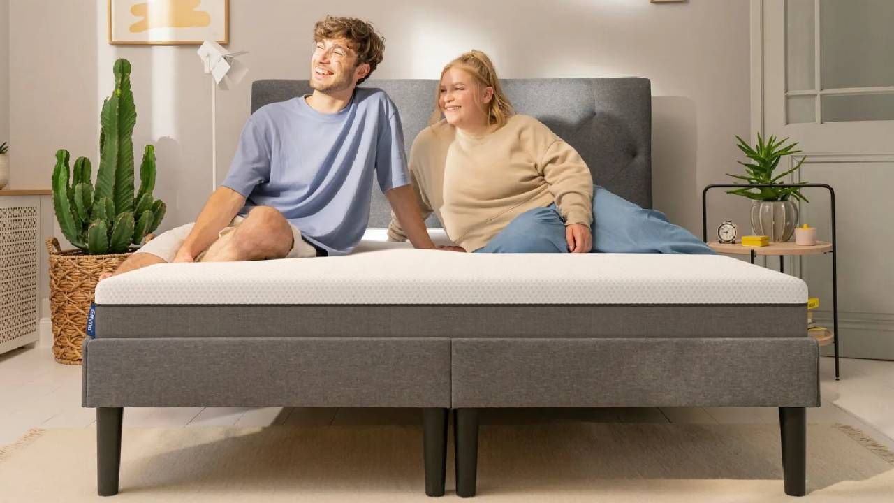 A man and a woman sitting on an Emma mattress