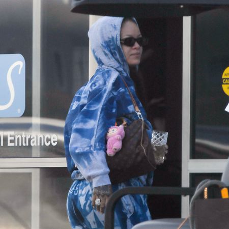 Rihanna arrives at the airport in a tie-dye sweatsuit with three designer bags by Dior and Louis Vuitton