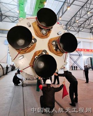 Staff members hoist the first-stage launcher of the Long March 2F rocket, which will carry China's new piloted spacecraft Shenzhou 10, at Jiuquan Satellite Launch Center.
