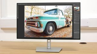 A Dell UltraSharp U2723QE monitor photographed on a desk