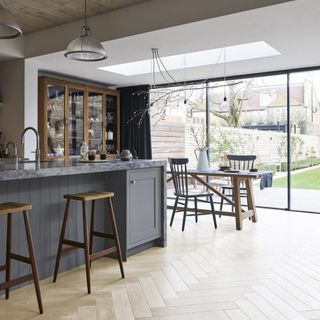 kitchen area with wooden floor and glass door and dinner table and chairs and grey counter