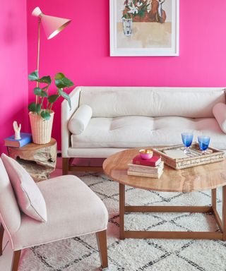 neon pink living room with white couch, white and black rug, wood coffee table, oatme