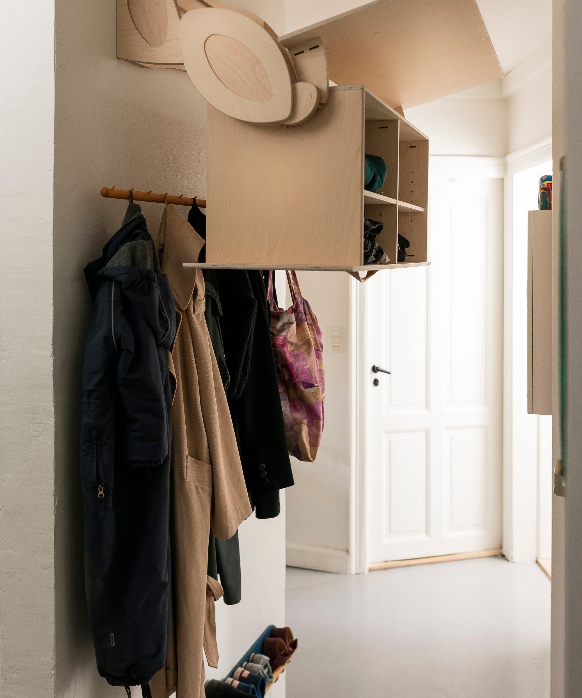 Entryway with smart built in storage cupboard and coats hanging on hooks