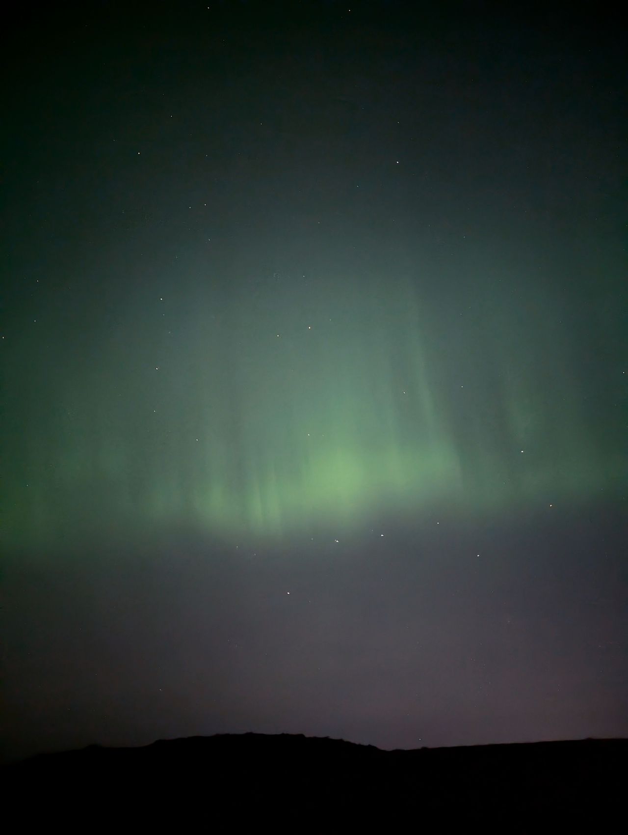 The Northern Lights' green pillars in the sky
