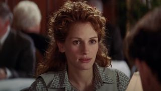 Julia Roberts sitting at a table in My Best Friend's Wedding.