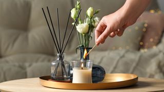 Someone lighting a glass candle