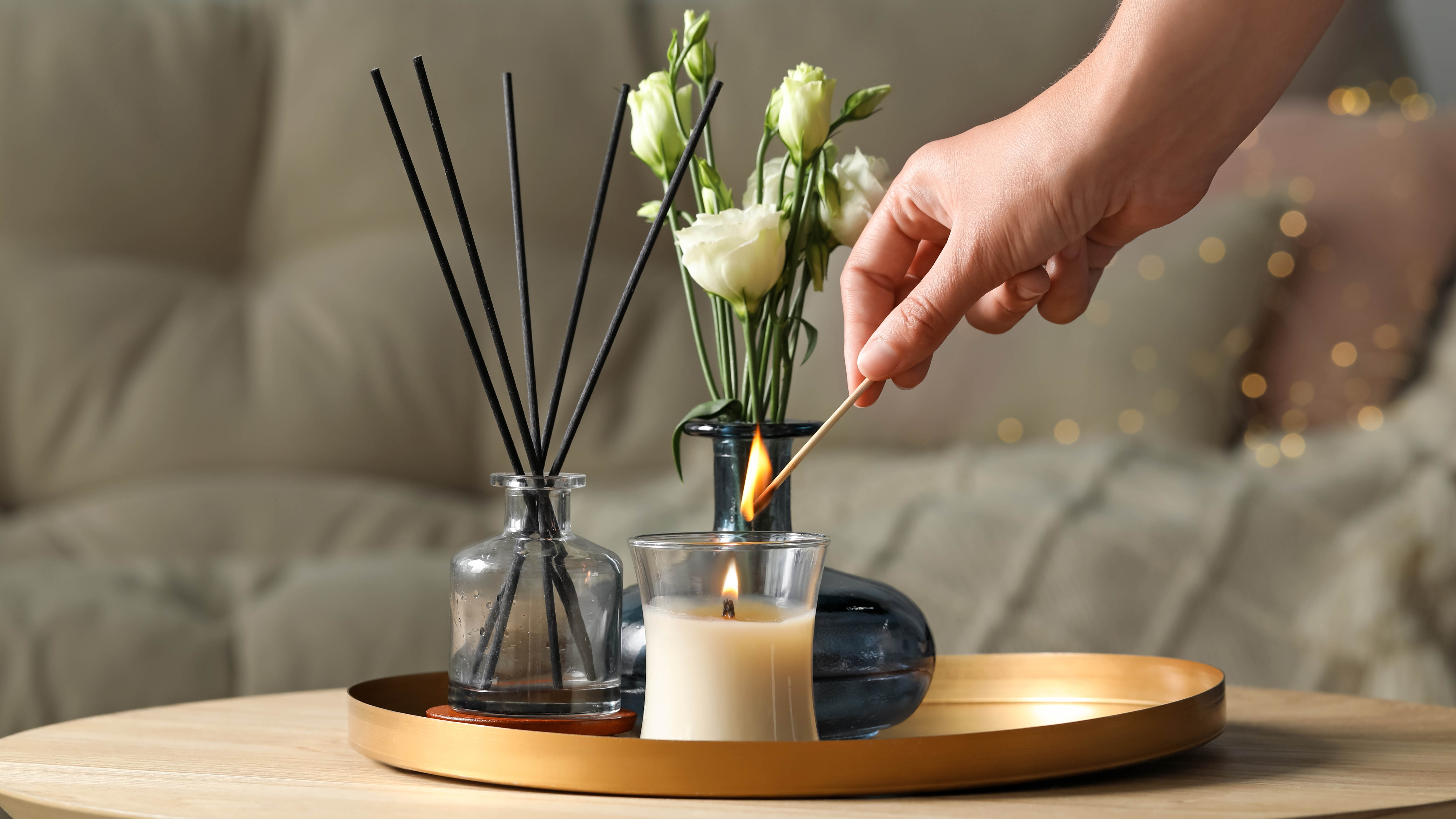 Someone lighting a glass candle