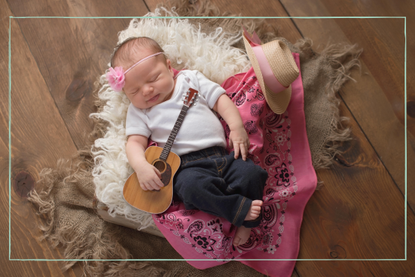 Baby with a guitar to represent baby names for musicians