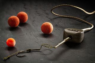 A carp fishing rig with boilies and a lead