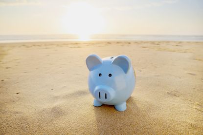 Blue piggy bank at beach during sunset 
