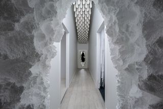 A white corridor with a mirror at the end.