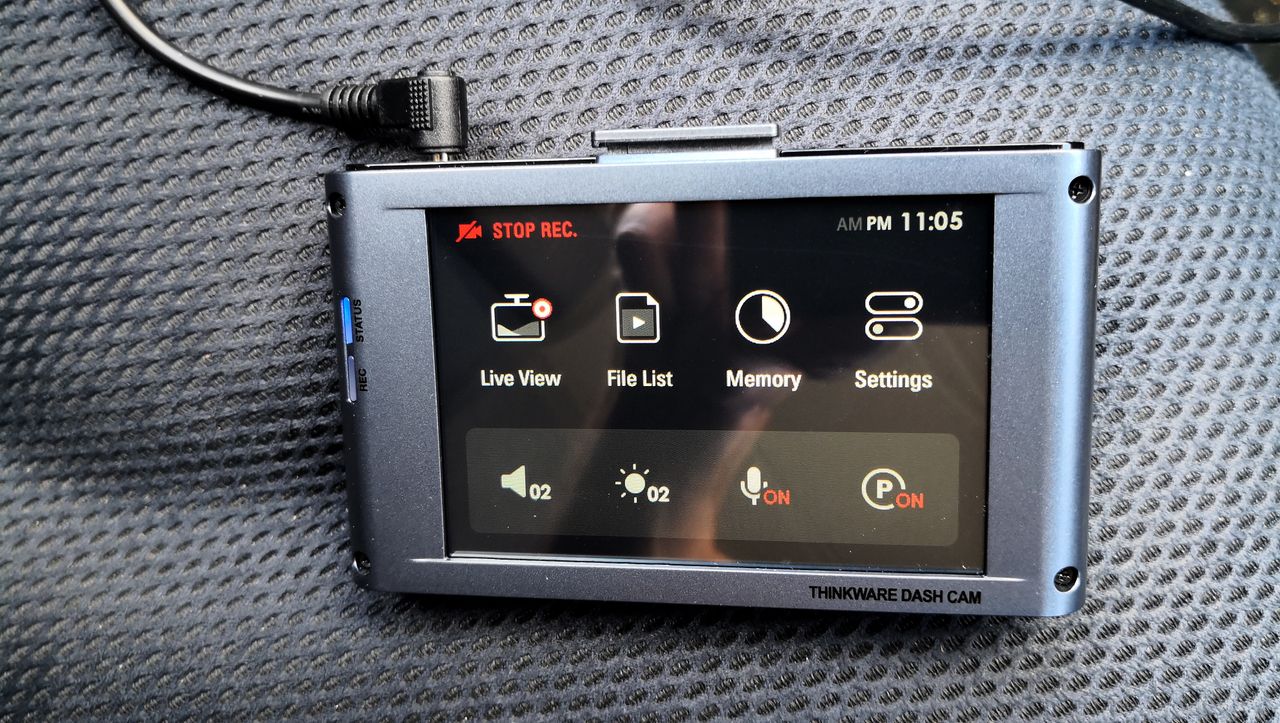 The Thinkware X1000 dash cam sitting on a car seat