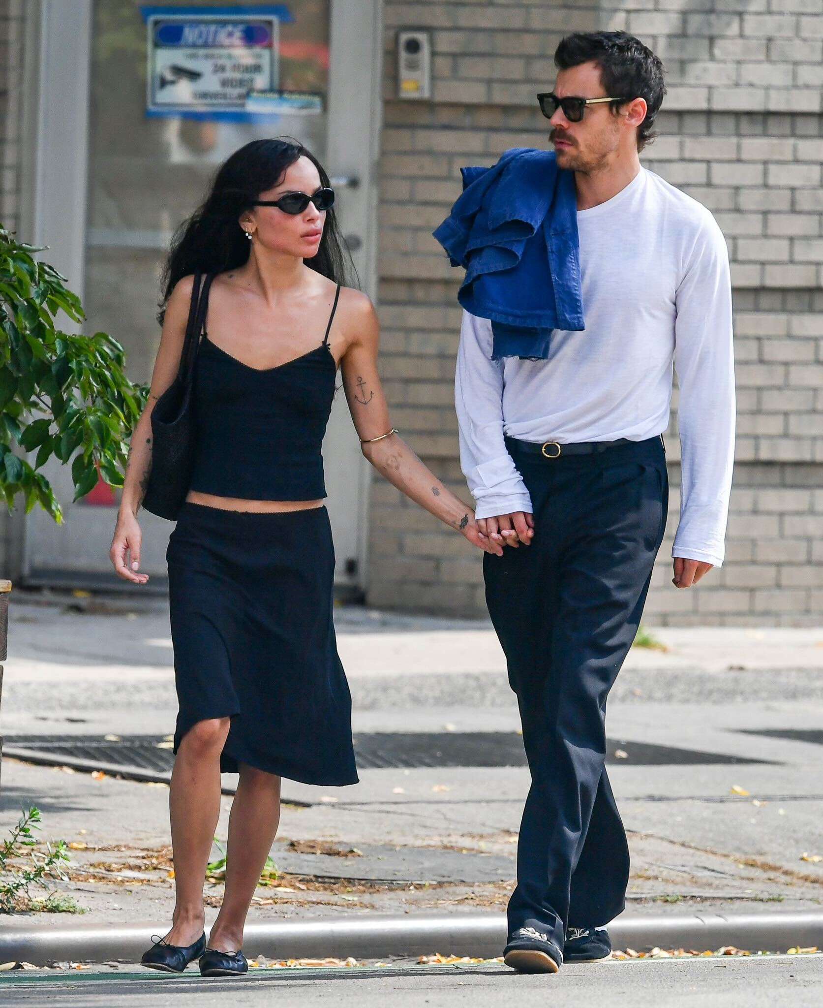Zoe Kravitz and Harry Styles walking in New York City. Zoe is wearing a Cou Cou Intimates camisole and black knee-length skirt.