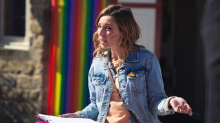 Andrea Tate stands by rainbow flag at Pride