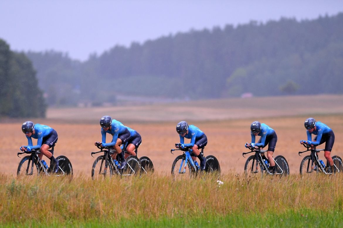 The women's Movistar team hold the wheels