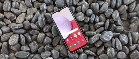 Samsung Galaxy A13 facing forward on a surface of pebbles