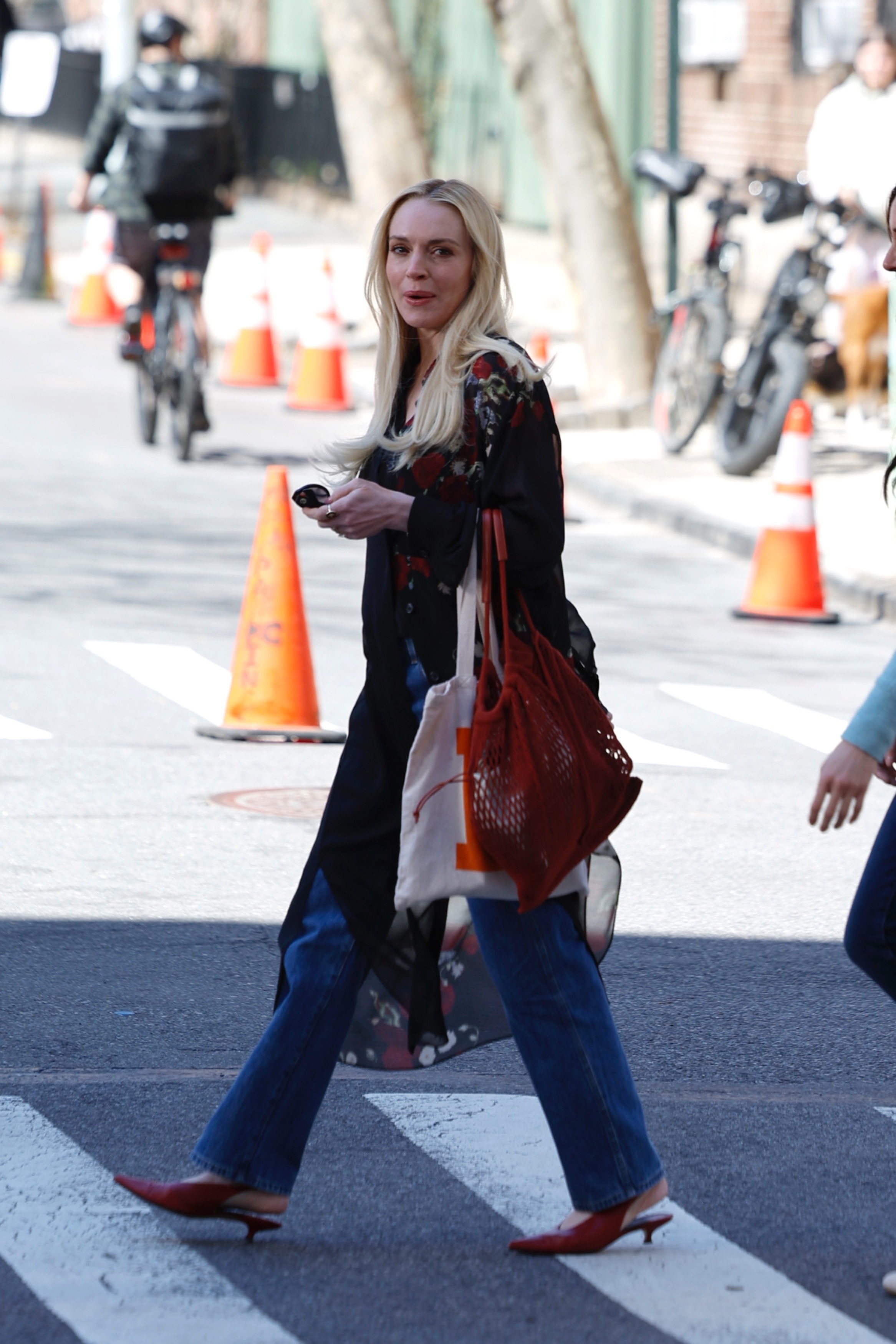 Lindsay Lohan walks down the street in New York wearing blue jeans with red pointed-toe slingbacks.