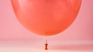 pin and red balloon on pink background