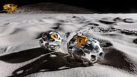 An illustration of two metal rounded objects on the moon's surface.