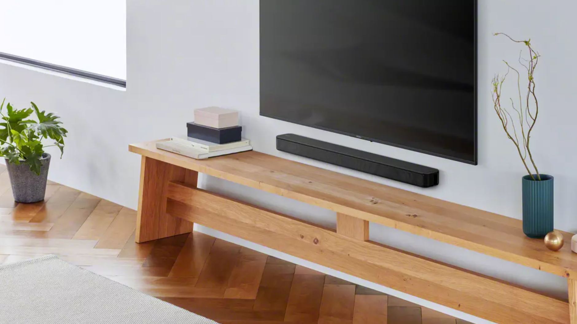 Sony HT-SF150 wallmounted beneath a TV and above a wooden unit